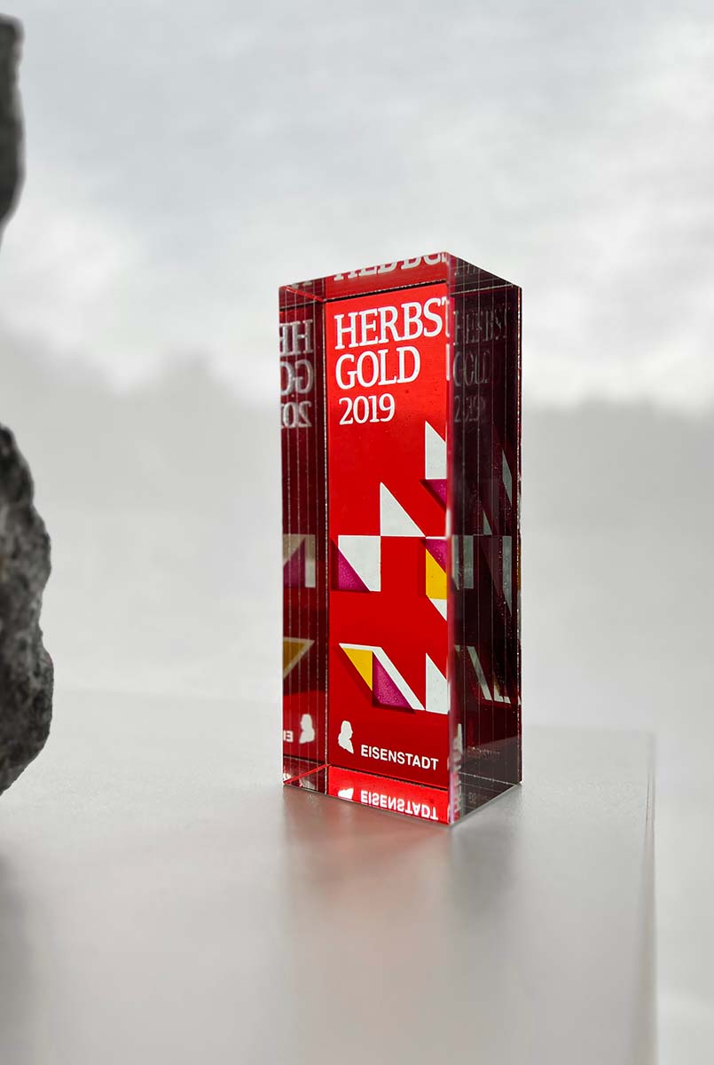 piros üvegdíj egy terméskő mellett