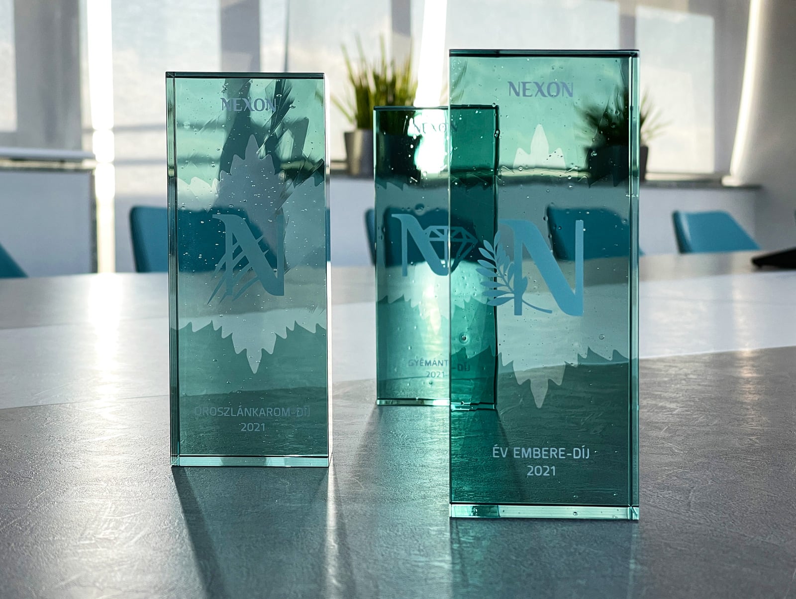 türkiz üvegdíjak egy irodai asztalon